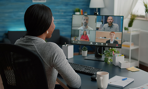 A woman having a meeting with her coworkers online.